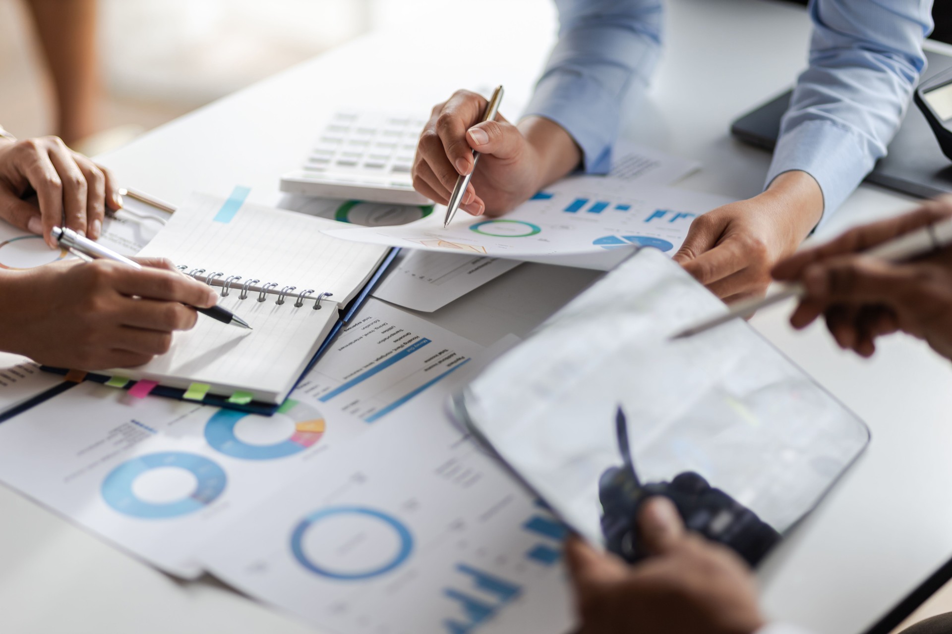Business consulting meeting is discussing business plan analysis with financial data and business growth charts to plan strategies for generating company profits.